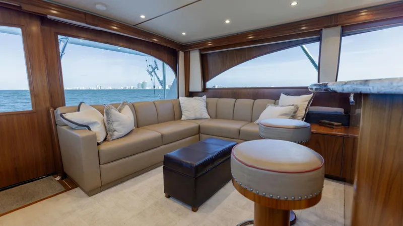Slide: The Image of Spacious Salon with Panoramic Views The salon of the 2020 Viking 62 Convertible offers a luxurious and inviting space with its plush L-shaped seating and elegant wood finishes. Large panoramic windows provide breathtaking views of the sea, enhancing the open and airy feel of the interior. T - 6711666