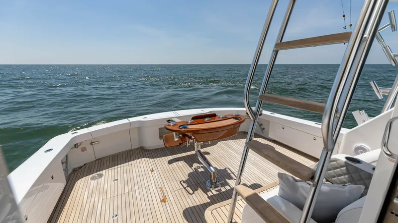Slide: The Image of Spacious Aft Deck with Ladder The aft deck of the 2020 Viking 62 Convertible offers a generous open space ideal for leisure and fishing activities. Featuring a sleek teak deck, this area is equipped with a central fighting chair and a sturdy ladder leading to the flybridge. The unobst - 6711696
