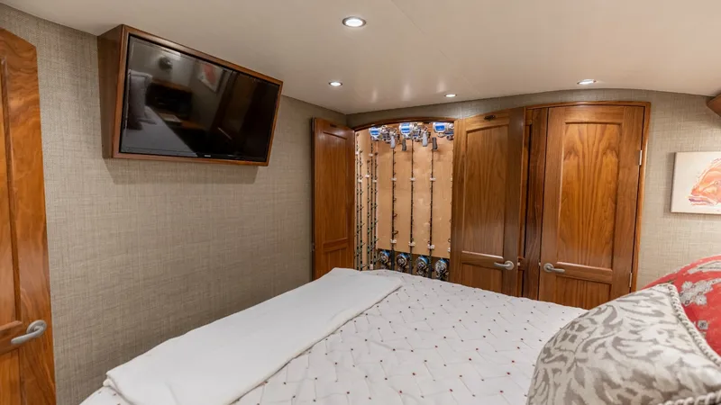 Slide: The Image of Luxurious Guest Stateroom with TV This cozy guest stateroom on the 2020 Viking 62 Convertible features elegant wood cabinetry and a plush bed, offering a comfortable retreat. The wall-mounted TV provides entertainment, while recessed lighting adds a warm, inviting ambiance. The well-craft - 6711679