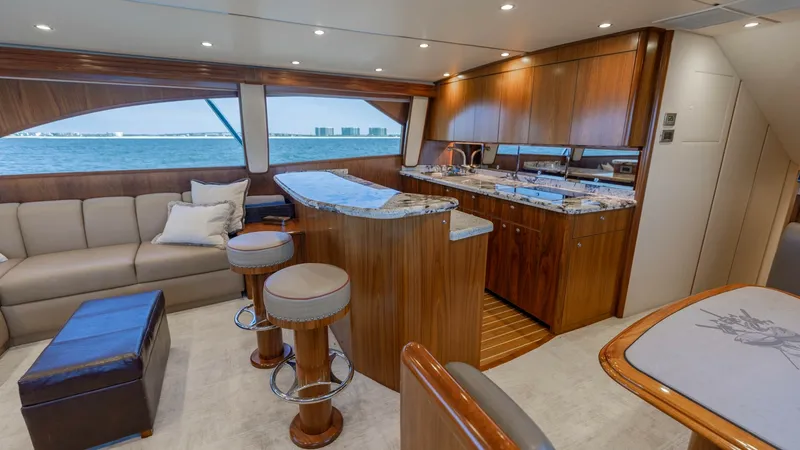Slide: The Image of Spacious Salon with Galley View This inviting salon of the 2020 Viking 62 Convertible features plush seating and a well-appointed galley. The warm wood finishes and soft lighting create an elegant and cozy atmosphere, ideal for entertaining. Large windows provide expansive views, enhanc - 6711667