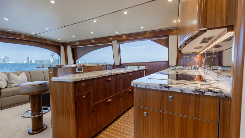 Slide: The Image of Luxury Galley with Ocean Views This elegant galley aboard the 2020 Viking 62 Convertible features exquisite wood cabinetry and sleek granite countertops, offering both style and functionality. Expansive windows provide panoramic ocean views, enhancing the open and airy feel of the spac - 6711670