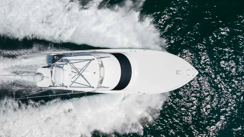 Slide: The Image of Aerial View of Bow Underway This striking aerial shot captures the Viking 62 Convertible slicing through the water with precision and power. The sleek, aerodynamic design of the bow is highlighted, showcasing its capability for smooth and fast navigation. The vessel's pristine white - 6711714