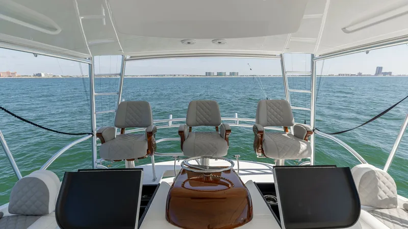 Slide: The Image of Flybridge Helm Station with Seating The flybridge helm station of the 2020 Viking 62 Convertible features state-of-the-art navigation displays and four luxurious captain's chairs. The open-air design provides a panoramic view of the surrounding waters, enhancing the overall cruising experie - 6711693