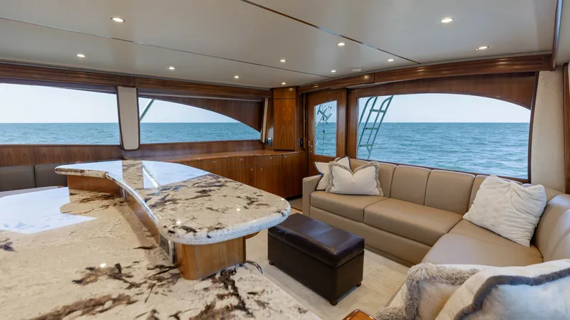 Slide: The Image of Salon with Ocean View and Seating The inviting salon of the 2020 Viking 62 Convertible features elegant seating and panoramic ocean views. A beautifully crafted stone countertop adds luxury, while the plush L-shaped sofa provides comfort for relaxation or socializing. Expansive windows fl - 6711665