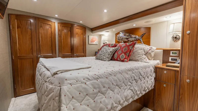 Slide: The Image of Luxurious Master Stateroom The master stateroom of the 2020 Viking 62 Convertible exudes elegance with its rich wood cabinetry and plush bedding. Soft, recessed lighting enhances the cozy atmosphere, while ample storage is provided by the beautifully crafted closets and drawers. Th - 6711676