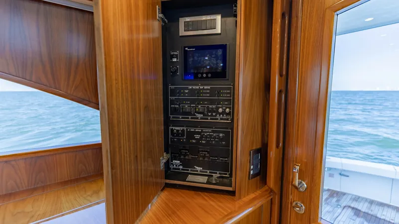 Slide: The Image of Electrical Control Panel Cabinet This image showcases the sophisticated electrical control panel housed within a sleek wooden cabinet on the Viking 62 Convertible. The panel is neatly organized, featuring state-of-the-art controls and a digital display for easy monitoring. The high-quali - 6711674