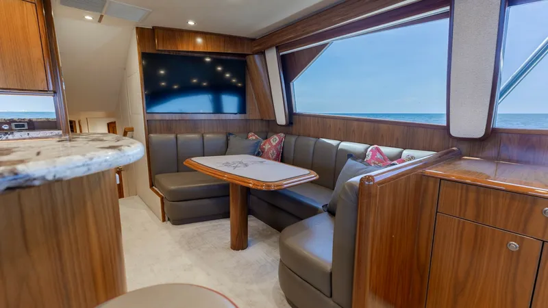 Slide: The Image of Salon with Plush Seating and TV The salon of the Viking 62 Convertible features luxurious L-shaped seating with plush cushions, perfect for relaxation. A large flat-screen TV is mounted on the wall, providing entertainment options while at sea. The space is enhanced by rich wood finishe - 6711673