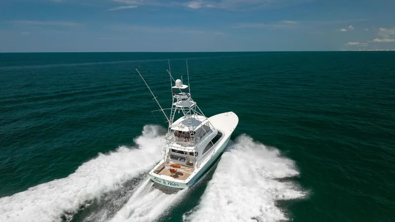 Slide: The Image of Aerial View of Yacht in Motion This impressive Viking 62 Convertible, 'Blue Water', glides effortlessly through the ocean, showcasing its sleek design and powerful performance. The aerial view captures the yacht's dynamic wake and expansive deck, emphasizing its capability for both lei - 6711717