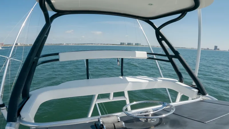 Slide: The Image of Flybridge Helm Station View The flybridge helm station of the Viking 62 Convertible offers an expansive view of the surrounding waters. Featuring a sleek steering wheel and state-of-the-art navigation controls, this area is designed for optimal functionality and comfort. The open-ai - 6711713