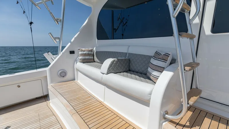 Slide: The Image of Aft Deck Seating Area with Steps This inviting aft deck on the 2020 Viking 62 Convertible features a comfortable seating area with plush cushions and stylish throw pillows. The teak decking provides a classic nautical touch, while the stainless steel handrails and steps offer easy access - 6711697