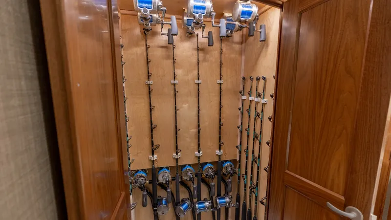 Slide: The Image of Custom Fishing Rod Storage Cabinet This elegant fishing rod storage cabinet aboard the 2020 Viking 62 Convertible showcases finely crafted woodwork with ample space for securing multiple rods. The vertical organization allows for easy access and efficient storage, utilizing high-quality ma - 6711680
