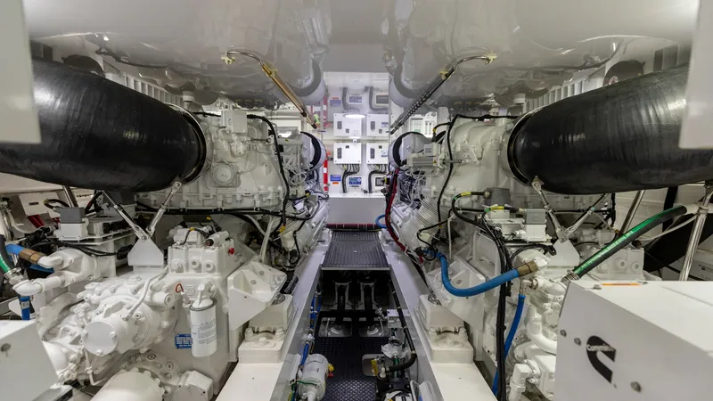 Slide: The Image of Engine Room with Twin Engines The engine room of the 2020 Viking 62 Convertible showcases twin powerful engines, meticulously arranged for optimal performance and accessibility. The space is well-organized with high-quality piping and wiring, ensuring reliability and efficiency. Brigh - 6711703