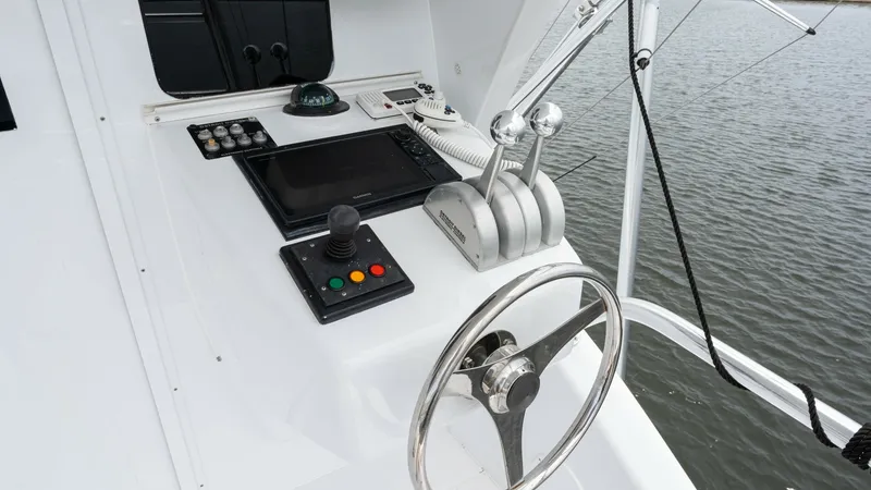 Slide: The Image of Enclosed Bridge Helm Station The helm station on the Viking 65 Enclosed Bridge showcases advanced navigation and control systems, featuring a sleek steering wheel and dual throttle controls. The array of modern electronics and a vibrant display screen ensure precise handling and navi - 6767190