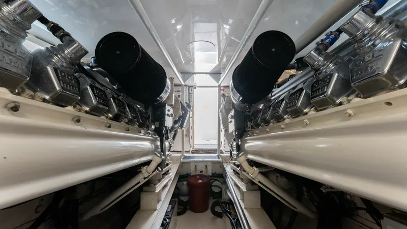 Slide: The Image of Engine Room with Twin Engines The engine room of the 2001 Viking 65 Enclosed Bridge 'Donna Maria' showcases powerful twin engines, meticulously maintained for optimal performance. The space is cleanly organized, with a pristine white finish enhancing the room's brightness. This setup - 6767198