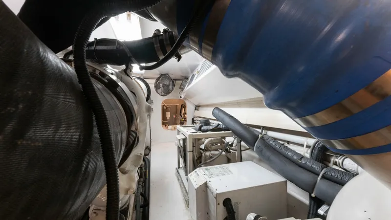 Slide: The Image of Engine Room with Machinery View The engine room of the 2001 Viking 65 Enclosed Bridge, Donna Maria, showcases robust machinery and efficient layout. Highlighted by a spacious corridor, the room features well-maintained engines and advanced plumbing systems, ensuring optimal performance. - 6767199