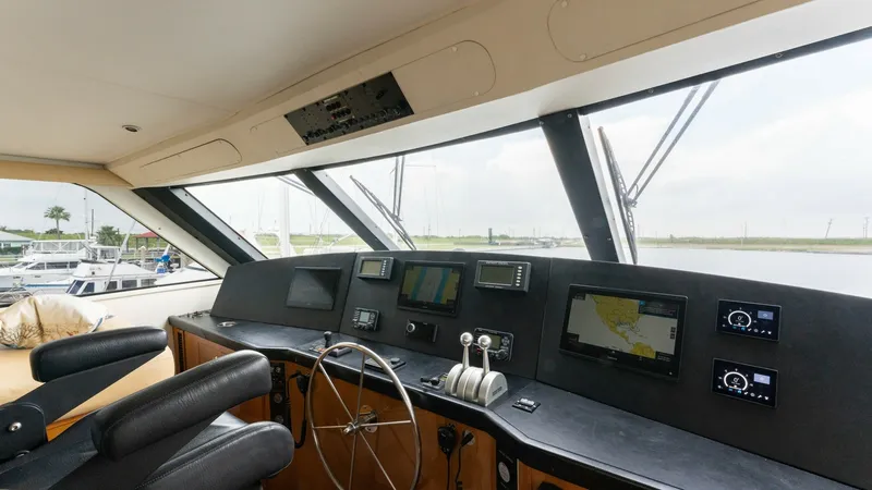 Slide: The Image of Enclosed Bridge Helm Station The helm station of the 2001 Viking 65 Enclosed Bridge offers a commanding view with large, panoramic windows. Equipped with advanced navigation systems and dual helm chairs, it ensures a comfortable and efficient piloting experience. The sleek, modern da - 6767185