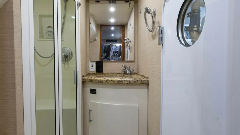 Slide: The Image of Viking 65 Enclosed Bridge Bathroom This elegant bathroom on the Viking 65 Enclosed Bridge features a compact and efficient layout. The space includes a glass-enclosed shower and a sleek vanity with a granite countertop, offering both functionality and style. Soft lighting and high-quality - 6767174