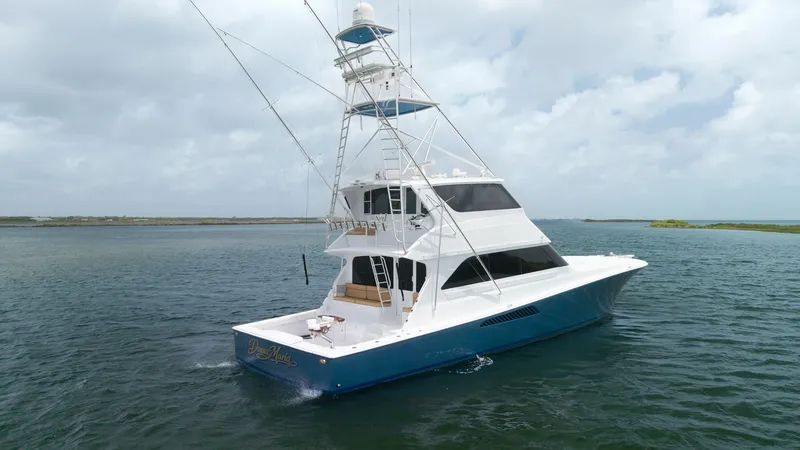 Slide: The Image of Aft View of Viking 65 Enclosed Bridge This image showcases the elegant aft view of the 2001 Viking 65 Enclosed Bridge, Donna Maria. Highlighting its spacious cockpit and sleek blue hull, the vessel exudes both functionality and style. The enclosed bridge offers enhanced visibility and comfort - 6767207