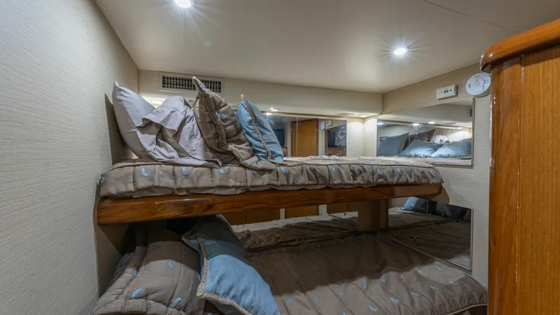 Slide: The Image of Guest Stateroom with Bunk Beds This cozy guest stateroom features well-appointed bunk beds, offering comfortable sleeping arrangements for additional guests. The warm wood finishes and soft lighting create a welcoming atmosphere. Ample storage and thoughtfully placed fixtures enhance t - 6767172