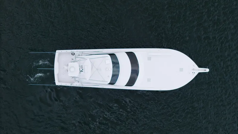 Slide: The Image of Aerial View of Enclosed Bridge This top-down image showcases the sleek design of the 2001 Viking 65 Enclosed Bridge. The spacious deck and distinct enclosed bridge are prominent, offering superior visibility and protection from the elements. The vessel's streamlined shape and elegant l - 6767211
