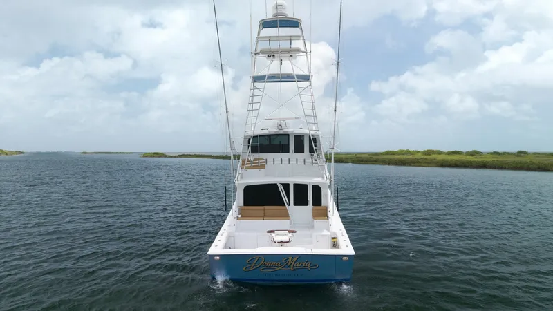 Slide: The Image of Aft View with Tower and Cockpit The aft view of the 2001 Viking 65 Enclosed Bridge showcases a spacious cockpit designed for both leisure and sportfishing. The vessel features a prominent tower, providing excellent visibility and control for navigating and fishing. With its sleek design - 6767208