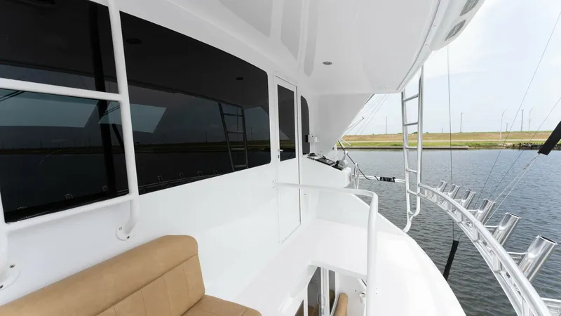Slide: The Image of Starboard Side Walkway with Seating This image showcases the starboard side walkway of the 2001 Viking 65 Enclosed Bridge. Featuring a plush tan bench seat, it provides a comfortable space for enjoying views while underway. The sleek design and ample handrails ensure safety, while the expan - 6767191