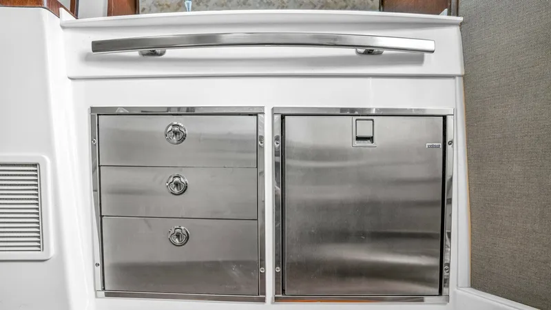 Slide: The Image of Galley Storage and Refrigerator This image showcases the sleek, stainless steel galley storage and refrigerator unit on the Grady-White Canyon 456. The modern design features three spacious drawers and a compact refrigerator, providing ample storage for provisions. The clean lines and p - 6725166