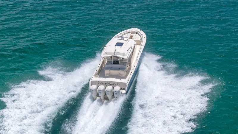 Slide: The Image of Aerial View of Stern in Motion This dynamic aerial shot captures the powerful performance of the Grady-White Canyon 456, showcasing its quad outboard engines as it glides effortlessly through the water. The spacious aft deck is designed for both fishing and leisure, providing ample roo - 6725204