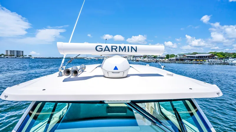 Slide: The Image of Helm Roof with Radar Equipment The helm roof of the 2021 Grady-White Canyon 456 showcases advanced Garmin radar equipment, ensuring superior navigation capabilities. The sleek design is complemented by a clear, expansive windshield offering unobstructed views for the captain. This setu - 6725180