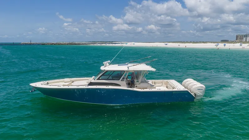Slide: The Image of Side Profile of Grady-White Canyon 456 This image showcases the sleek side profile of the 2021 Grady-White Canyon 456. The vessel's deep blue hull contrasts beautifully with the vibrant ocean, highlighting its elegant design. Equipped with powerful outboard engines, this model promises excepti - 6725194