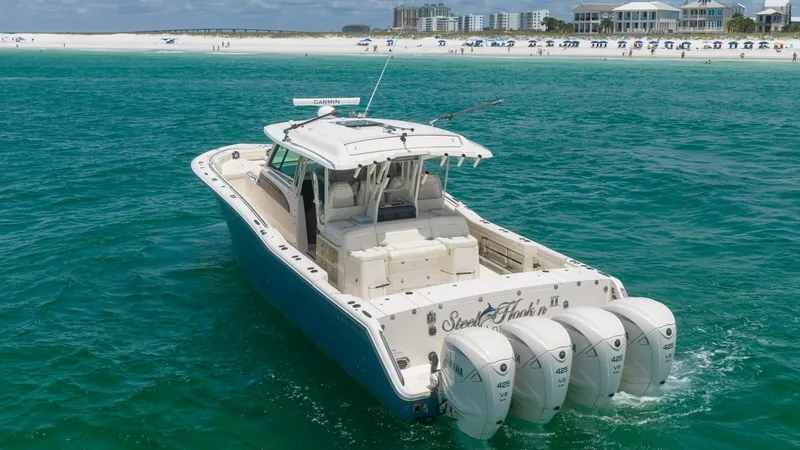 Slide: The Image of Aft Deck and Quad Engines View The Grady-White Canyon 456 'Steel Hook'N II' showcases its impressive aft deck, complemented by four powerful outboard engines, designed for exceptional performance. The spacious layout features ample seating and a sturdy T-top, ideal for both relaxation - 6725205