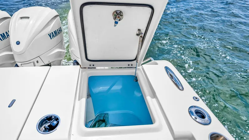 Slide: The Image of Aft Deck Livewell and Engines This image showcases the aft deck of the Grady-White Canyon 456, featuring a spacious livewell with a secure lid for easy access to bait and catch. The deck is complemented by robust Yamaha engines, ensuring powerful performance on the water. The sleek de - 6725186