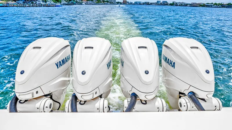 Slide: The Image of Quad Yamaha Outboard Engines This image showcases the powerful quad Yamaha outboard engines on the 2021 Grady-White Canyon 456, Steel Hook'N II. These engines provide exceptional performance and reliability, ideal for offshore adventures. The pristine waters in the background emphasi - 6725189