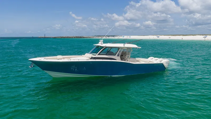 Slide: The Image of Side Profile on Open Water The 2021 Grady-White Canyon 456 is showcased cruising in vibrant turquoise waters. Its sleek blue hull and elegant lines are complemented by a spacious deck, ideal for both leisure and sport. The sturdy hardtop and aerodynamic silhouette enhance its appea - 6725193