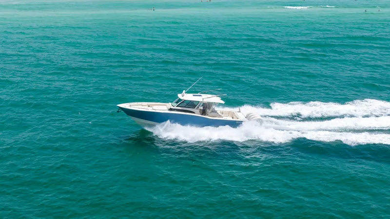 Slide: The Image of Side View Cruising Offshore The Grady-White Canyon 456 is seen powering through open waters, showcasing its sleek hull design and robust performance. The vessel's spacious deck and advanced helm station are highlighted, offering a glimpse of its luxurious and functional layout. With - 6725198