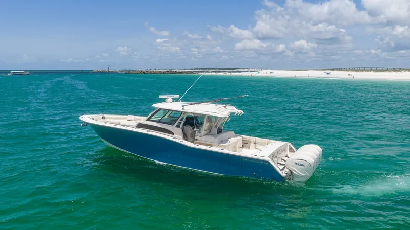 Slide: The Image of Side View of Grady-White Canyon 456 This striking side view showcases the Grady-White Canyon 456 gliding through vibrant turquoise waters. The vessel's sleek hull design and spacious deck are complemented by powerful Yamaha outboard engines, promising both performance and luxury. Perfect fo - 6725195