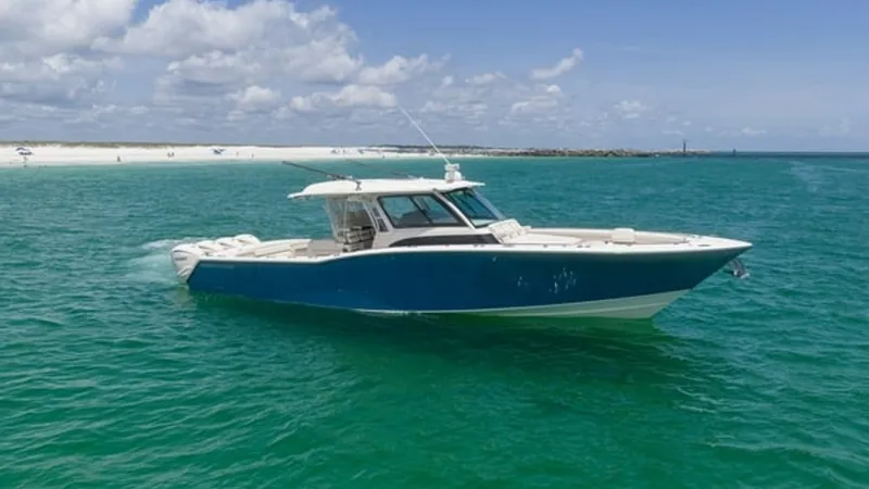 The Image of Side View of Grady-White Canyon 456 The Grady-White Canyon 456 showcases a sleek and powerful profile as it glides through clear blue waters. Its striking blue hull contrasts beautifully with the azure sea, reflecting the craftsmanship and quality synonymous with Grady-White. This vessel of - 6725154