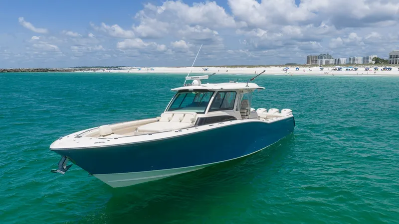 Slide: The Image of Bow and Side View in Open Water This image showcases the sleek profile of the Grady-White Canyon 456, emphasizing its spacious bow with ample seating. The striking blue hull contrasts beautifully with the clear turquoise water, highlighting the vessel's modern design and luxury appeal. - 6725192
