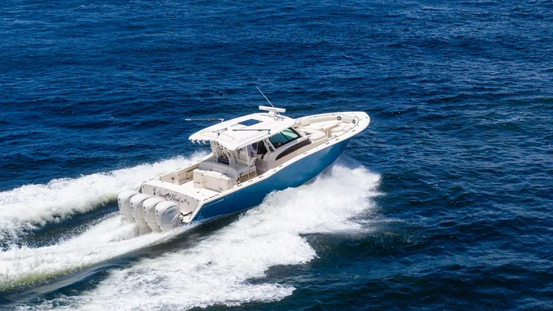 Slide: The Image of Aerial View of Grady-White Canyon 456 This aerial shot captures the Grady-White Canyon 456 slicing through the water with impressive power. The vessel is equipped with four robust outboard engines, providing exceptional speed and performance. Its sleek design and spacious deck layout make it - 6725203