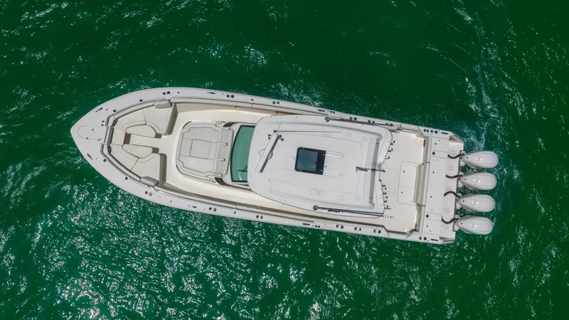 Slide: The Image of Aerial View of Grady-White Canyon 456 This aerial shot showcases the Grady-White Canyon 456's sleek design and spacious layout. The vessel features a prominent center console and ample deck space, ideal for both relaxation and adventure. With four powerful outboard engines, this model promise - 6725202
