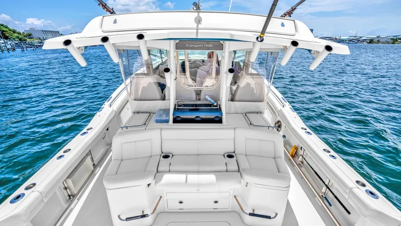 Slide: The Image of Spacious Aft Deck with Seating The aft deck of the 2021 Grady-White Canyon 456 offers ample seating with plush, cushioned benches, perfect for relaxation and social gatherings. The design incorporates built-in cup holders and storage, enhancing functionality without compromising on ele - 6725174