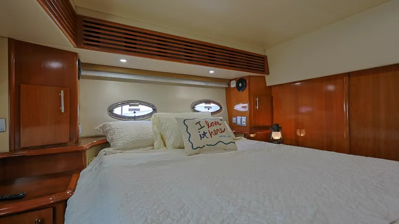 Slide: The Image of Cozy Forward Stateroom The forward stateroom of the 2006 Carver 396 Motor Yacht offers a warm and inviting retreat. Featuring elegant wood finishes and ambient lighting, this space is designed for comfort and relaxation. Twin porthole windows provide natural light, enhancing th - 8273181