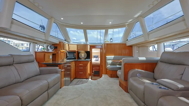 Slide: The Image of Spacious Salon with Panoramic Windows The salon of the 2006 Carver 396 Motor Yacht boasts an inviting and spacious layout, featuring luxurious leather seating and rich wood finishes. Expansive panoramic windows flood the interior with natural light, enhancing the open and airy feel. The well- - 8273171