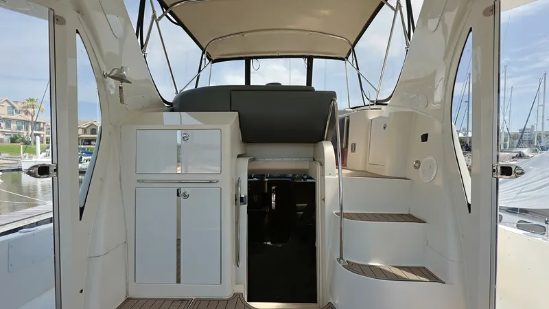 Slide: The Image of Flybridge Entryway and Helm Station This inviting flybridge entryway on the 2006 Carver 396 Motor Yacht features a well-designed helm station, ensuring easy navigation and control. The area is elegantly finished with teak flooring and provides ample storage within sleek cabinetry. The overh - 8273188
