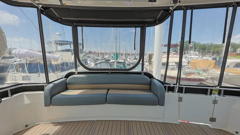 Slide: The Image of Enclosed Aft Deck Seating Area The enclosed aft deck of the 2006 Carver 396 Motor Yacht features a comfortable seating area with panoramic views. The space is equipped with plush upholstery and surrounded by large windows, offering an abundance of natural light. Ideal for relaxation or - 8273161