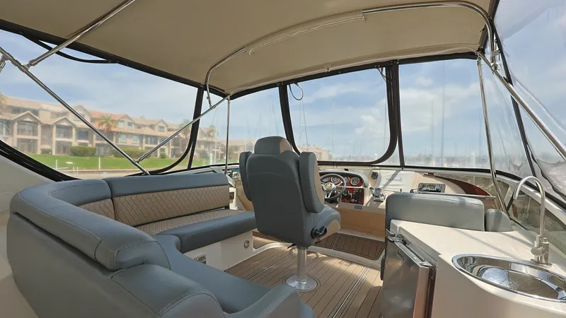 Slide: The Image of Flybridge with Helm and Seating The flybridge of the 2006 Carver 396 Motor Yacht offers an expansive view with comfortable seating and a well-equipped helm. The area features plush, cushioned seating and a sleek, modern dashboard for easy navigation. Large windows provide ample natural - 8273155