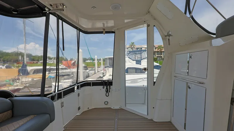Slide: The Image of Enclosed Aft Deck with Seating The enclosed aft deck of the 2006 Carver 396 Motor Yacht features expansive windows, allowing for panoramic views and abundant natural light. The area is equipped with comfortable seating, perfect for relaxation or entertaining guests. High-quality, weath - 8273163