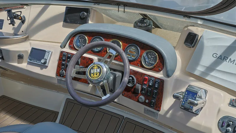 Slide: The Image of Helm Station with Instrument Panel The helm station of the 2006 Carver 396 Motor Yacht 'Serendipity' features a classic wood-grain instrument panel with easy-to-read gauges and controls. The ergonomic steering wheel provides comfortable handling, while modern navigation systems are within - 8273158