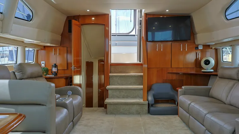 Slide: The Image of Spacious Interior Salon with Entertainment Center The salon of the 2006 Carver 396 Motor Yacht features plush leather seating and a rich wood finish, creating a warm and inviting atmosphere. A built-in entertainment center with a flat-screen TV offers relaxation and leisure opportunities. Large windows a - 8273167
