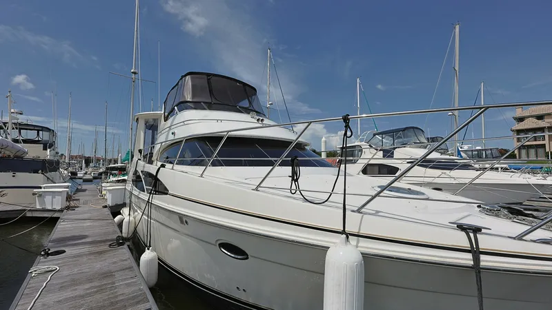 Slide: The Image of Starboard View at Dock The 2006 Carver 396 Motor Yacht, Serendipity, is shown moored at the dock, highlighting its sleek starboard profile. The spacious flybridge is covered with a protective bimini, offering ample space for navigation and relaxation. The polished stainless ste - 8273192